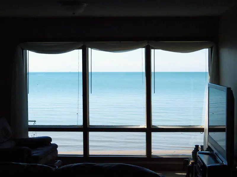 Triple Glazing in Newcastle upon Tyne Calm sea view through a large window, illustrating triple glazing for homes in Newcastle upon Tyne
